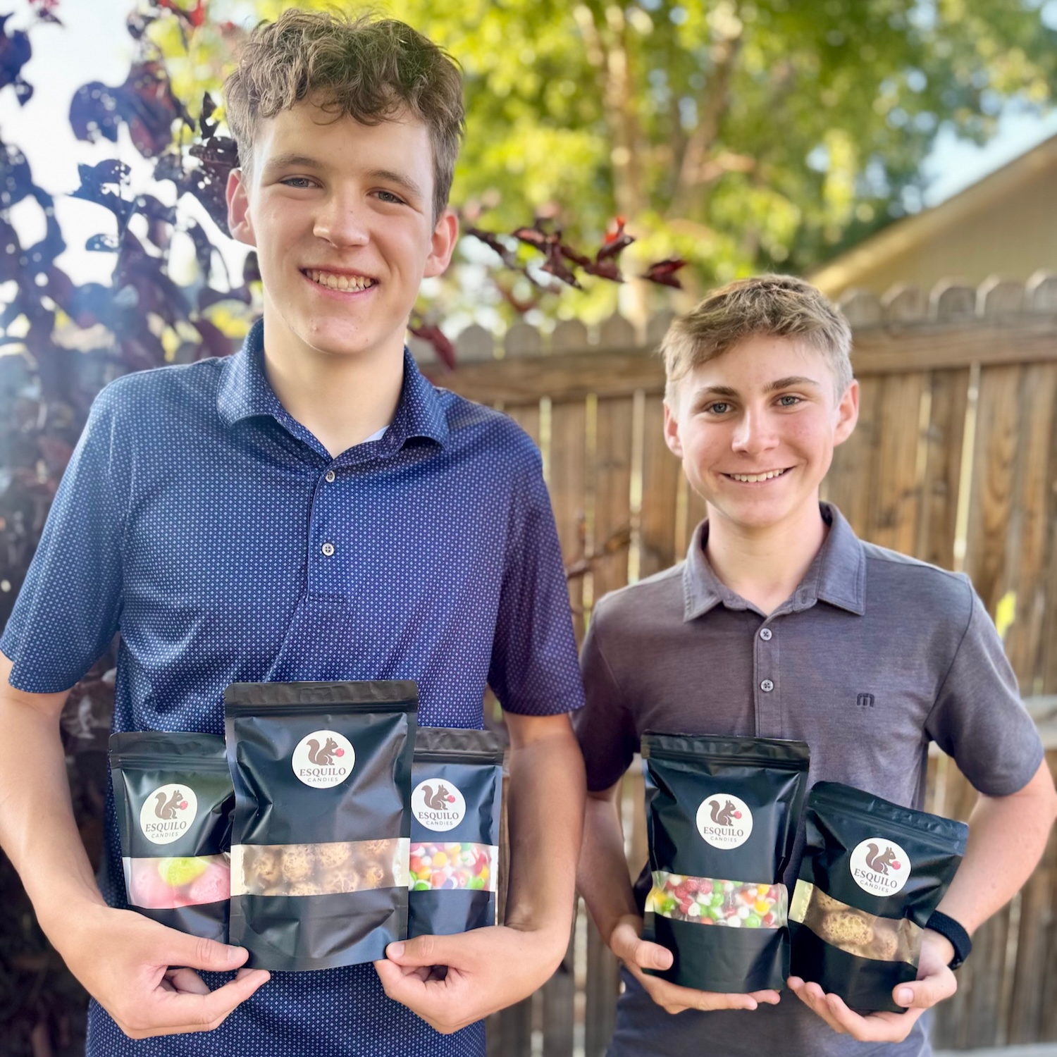 Highlands Ranch Freeze Dried Candy business co-founders Dylan and Bennett holding branded Esquilo Candies bags in backyard
