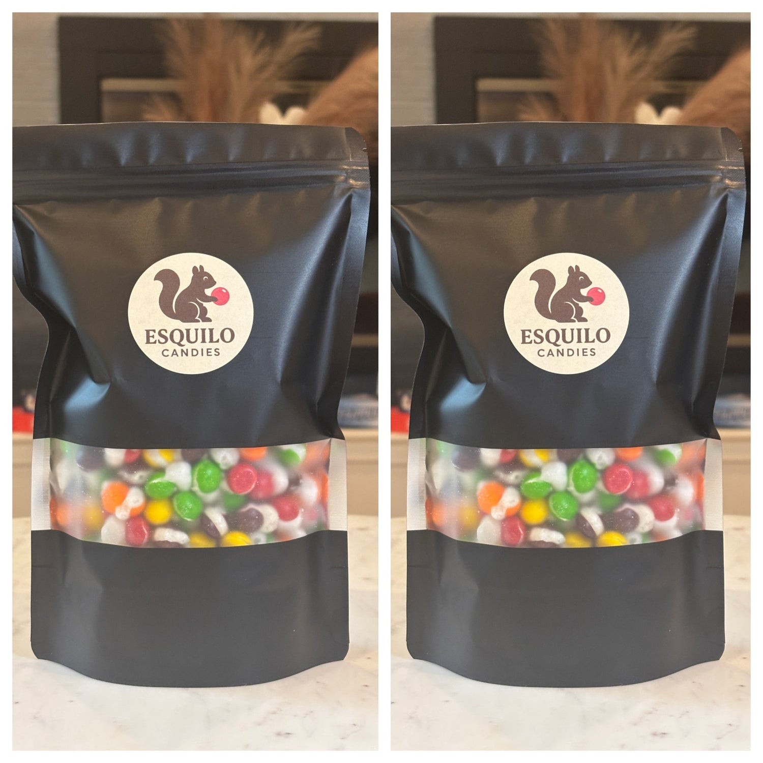 Two black bags with 'Esquilo Candies' logo containing colorful candies on a wooden surface.