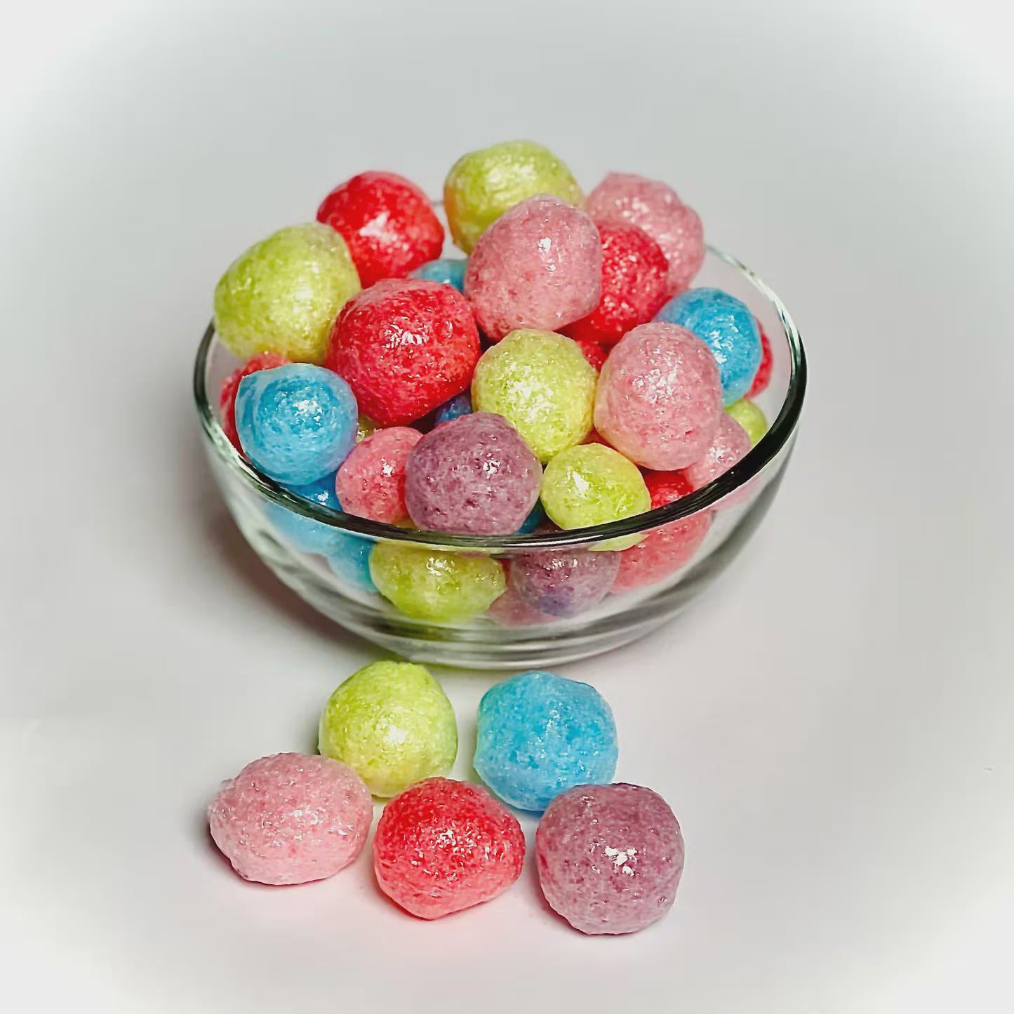 Glass bowl filled with freeze-dried jolly ranchers on a white background